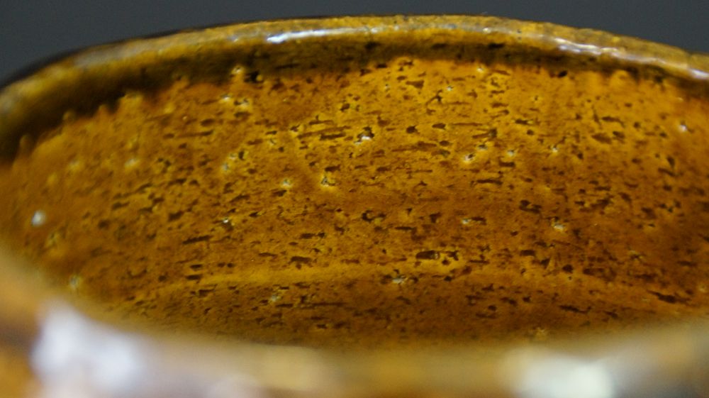 Close-up of the textured honey-colored interior glaze of the chawan made of Raku ware