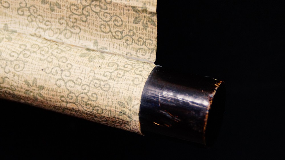 Close-up of the black lacquered scroll end of the kakemono