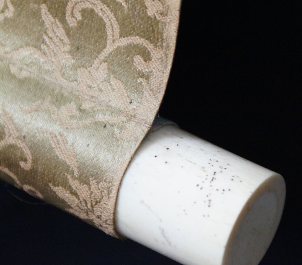 Detail view of the scroll end with ivory finial and gold brocade silk of the kakemono