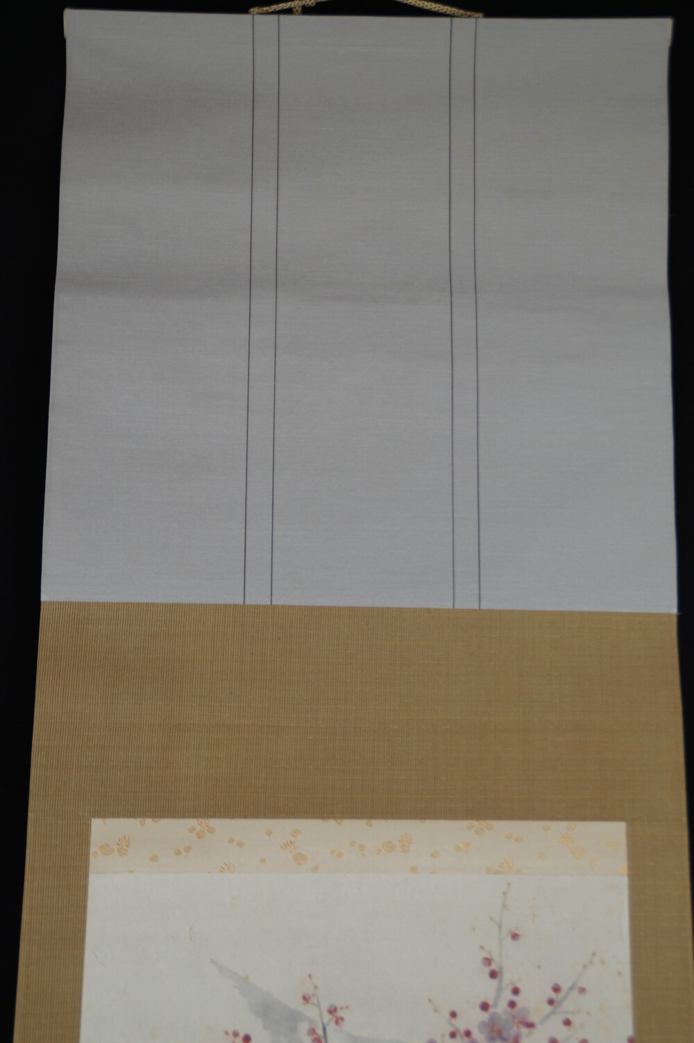 Detail view of the light gray silk mounting with binding cords in the Kakemono Plum Blossoms in Quiet Early Light by Tokuoka Shinsen