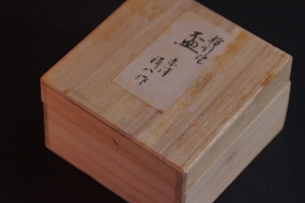 Close-up of the box lid with paper label and signature of the master potter