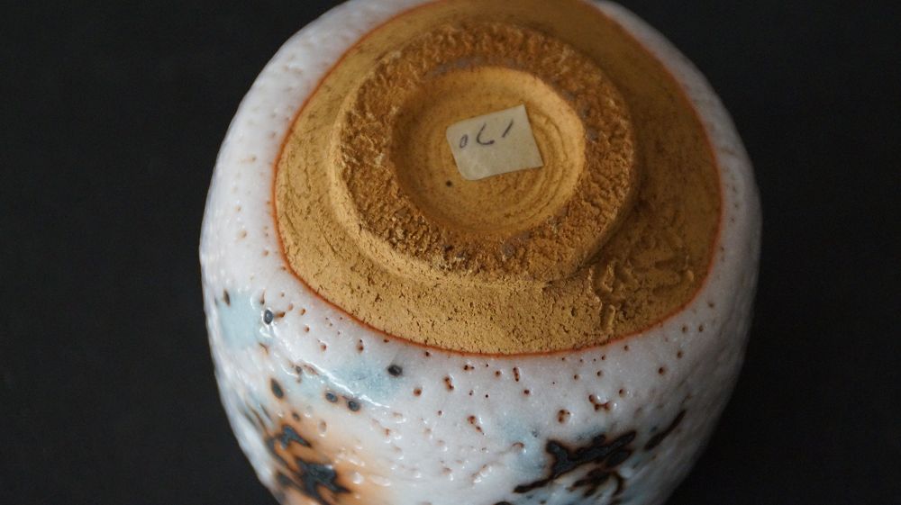 Close-up of the base with unglazed foot and handwritten numbering of the guinomi made of Shino ware by Takeshi Kato