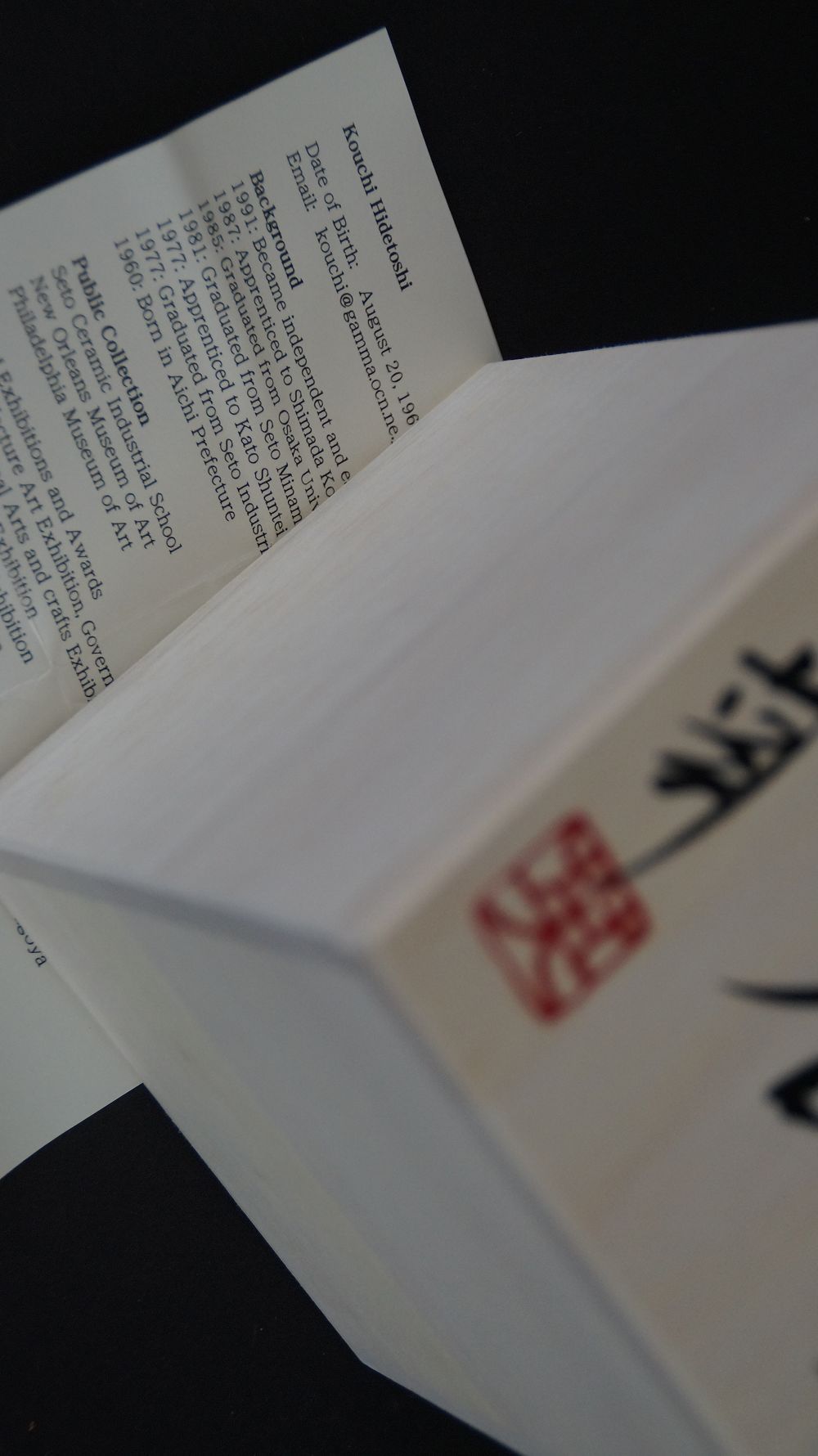 Signed box lid with red artist seal next to the artist biography of the Yunomi Tea Bowl Made of Oribe Ware