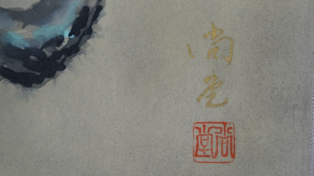 Detail view of the gold-colored artist's signature and the red seal in the Kakemono Songbird at the Blossoming Plum Tree