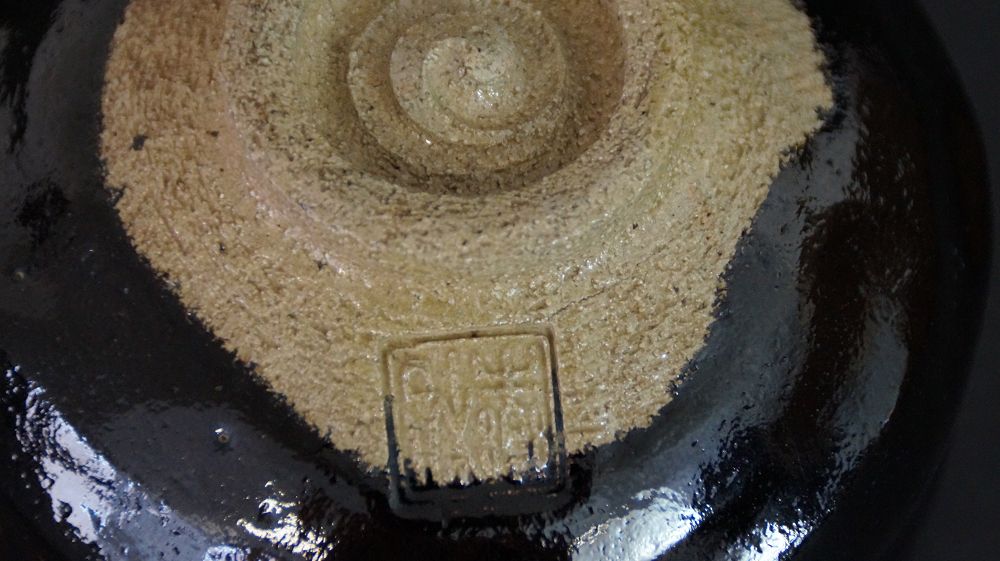 Detail view of the foot with impressed artist's seal of the chawan made of Raku ware