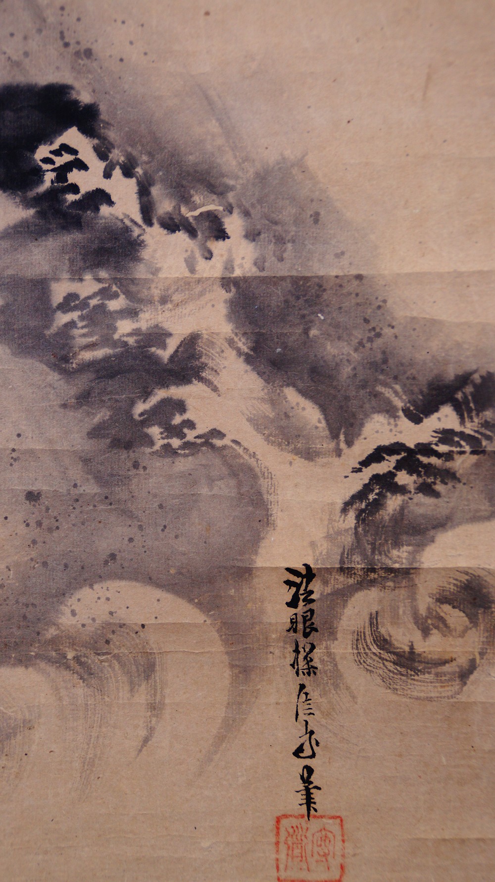 Another view of the waves and rocks next to the signature and the red seal of the hanging scroll