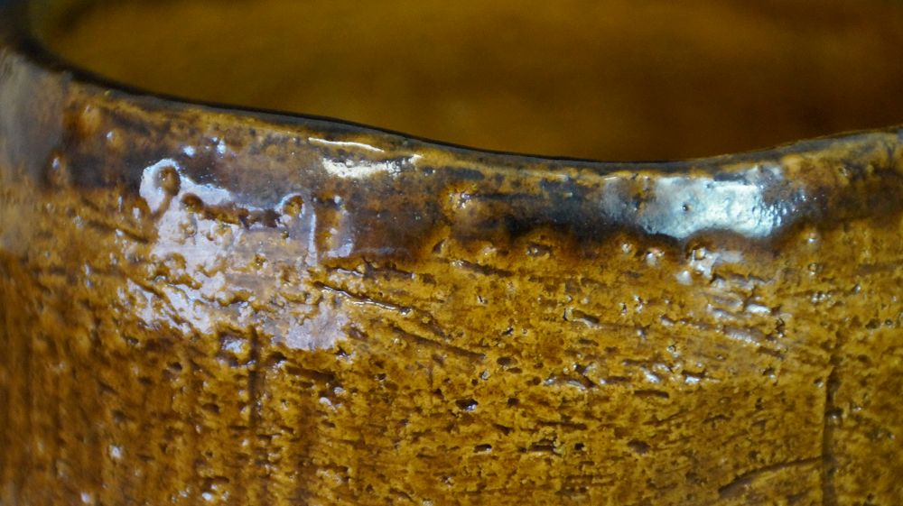 Close-up of the dark-speckled rim of the chawan made of Raku ware