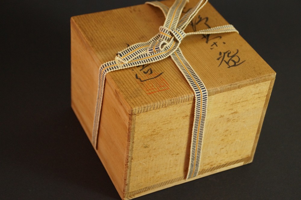 Close-up of the ink inscription Shino Chawan with red seal on the corded box