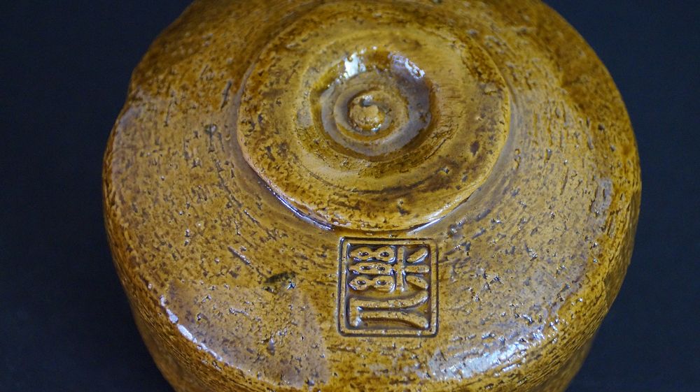 Detail view of the foot with impressed artist's seal of the chawan made of Raku ware