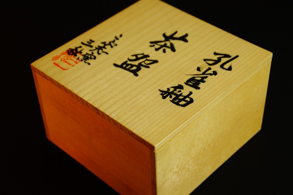 Close-up of the ink inscription Kujaku-yu Chawan with red seal on the box lid