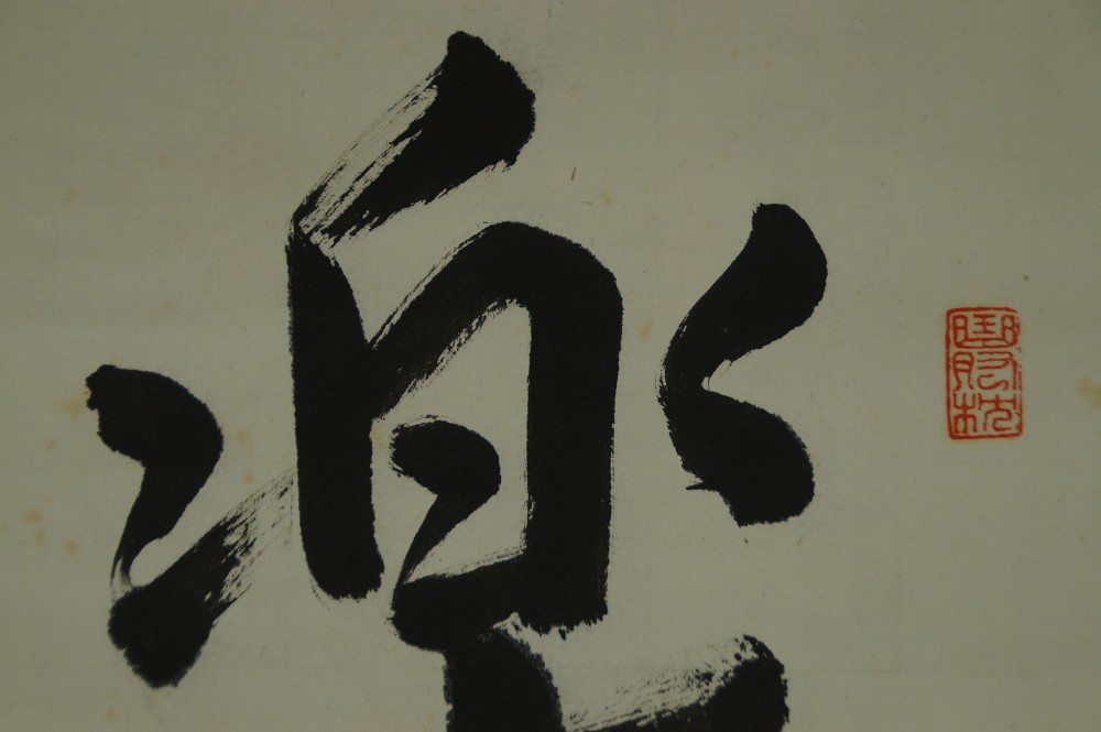 Close-up of the upper part of the character Raku with red seal