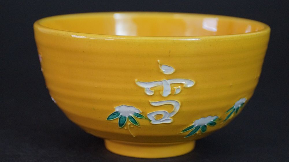 Further view of the chawan made of Kyoto ware with white-applied character and chrysanthemum motif