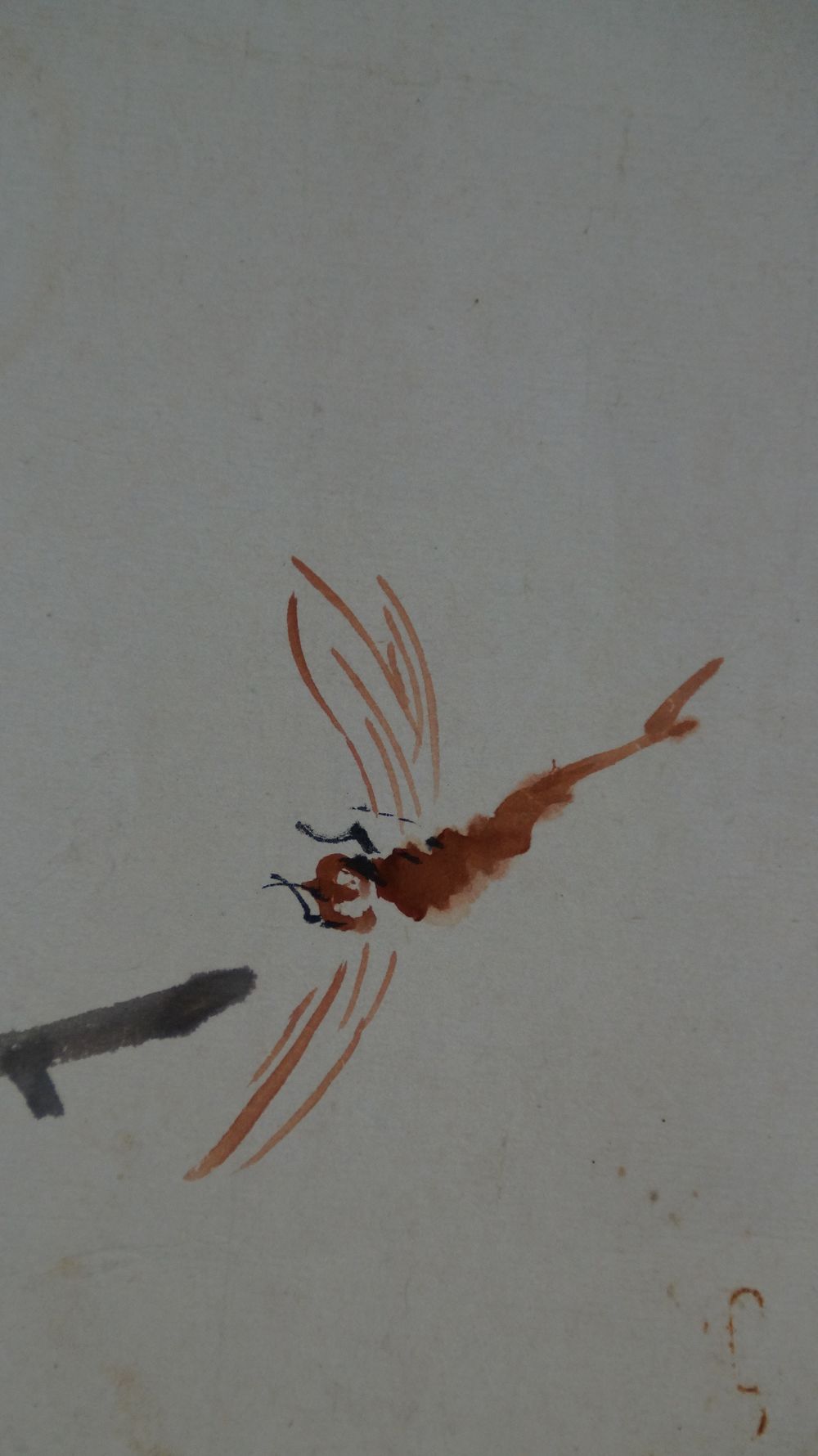 Close-up of the dragonfly painted in red on the bamboo stalk in the Makuri Black Cat and Dragonfly