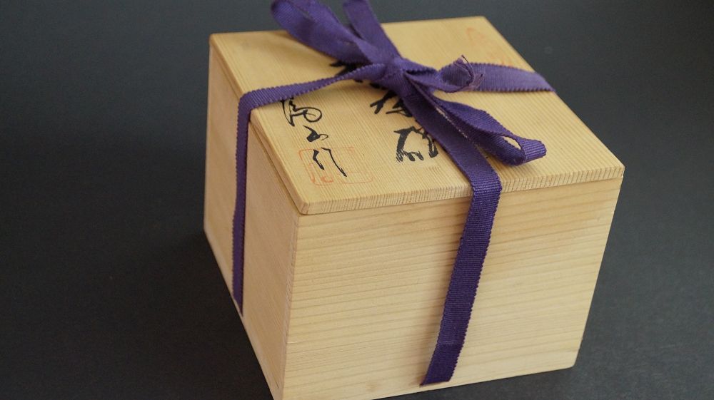 Closed storage box of the chawan made of Shino ware, tied with a purple cord