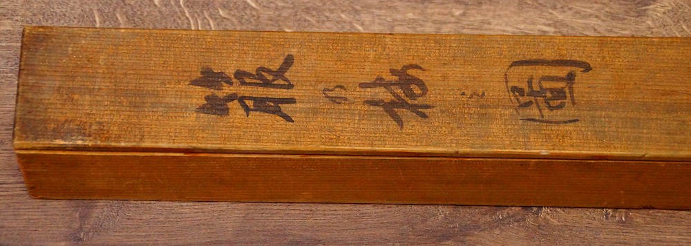 Close-up of the ink inscription and the red seal on the lid of the storage box