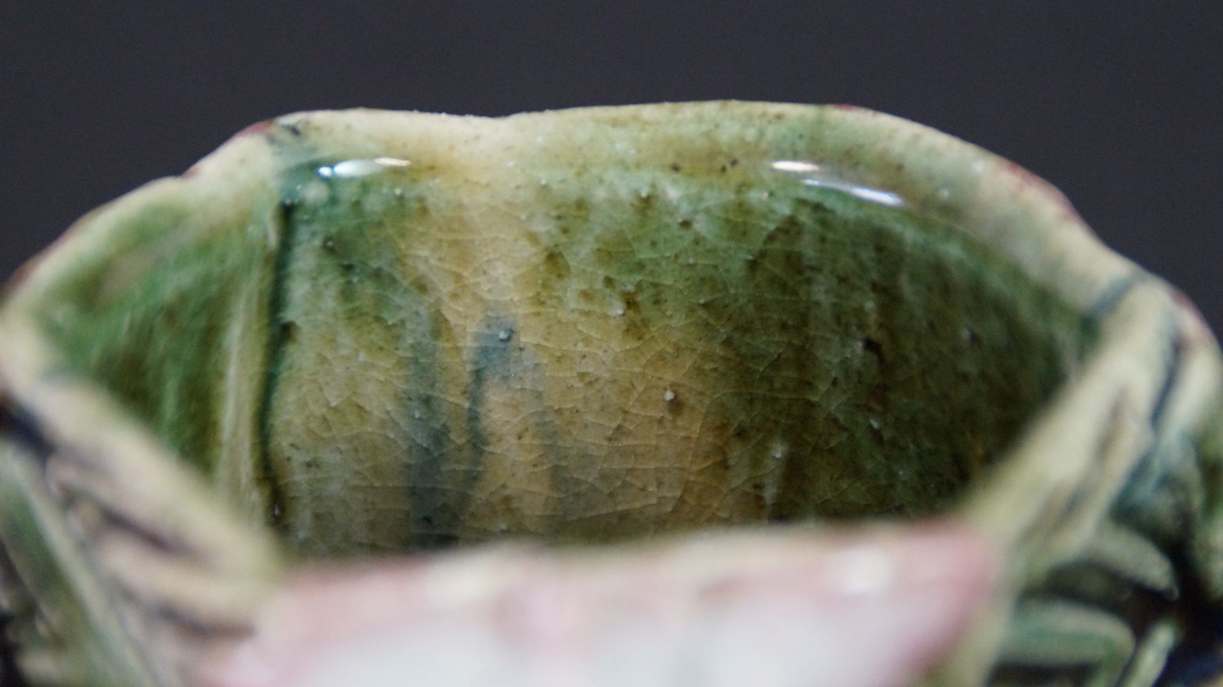 Close-up of the crackled green-yellow interior glaze of the guinomi sake cup made of Oribe ware