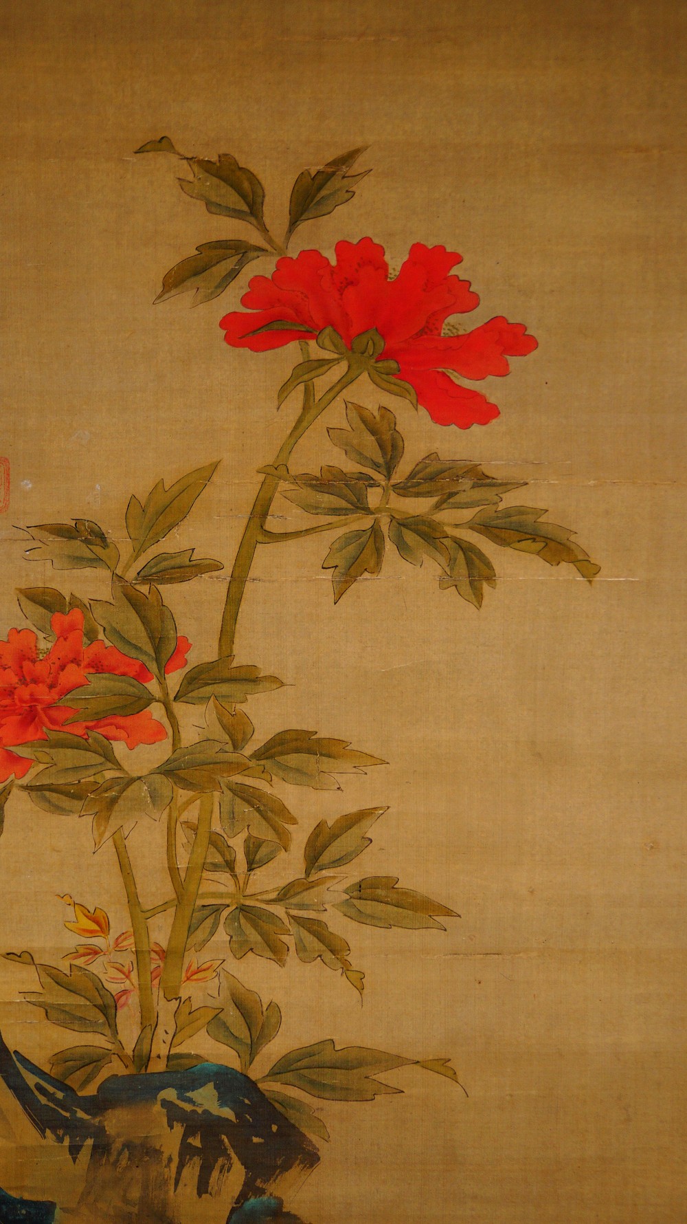Close-up of the peonies and the rock with a small blossoming branch