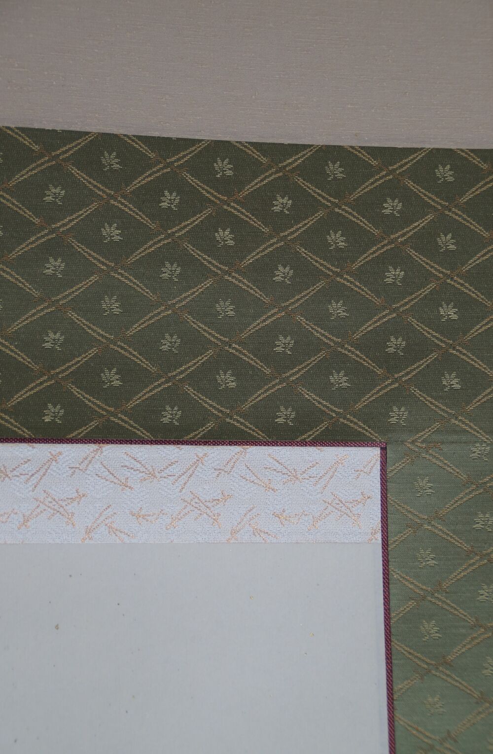 Detail view of the green diamond-pattern silk mounting with cream-colored border of the kakemono Pale Pink Plum Blossoms in Spring Light