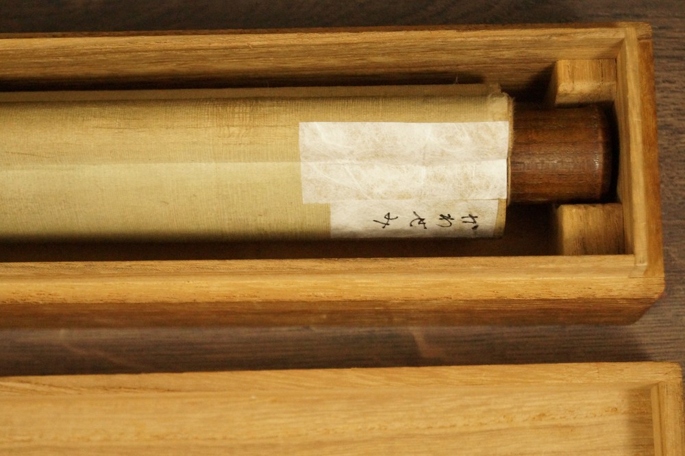 Rolled-up hanging scroll with paper label in open wooden box hanging scroll rolled up 1
