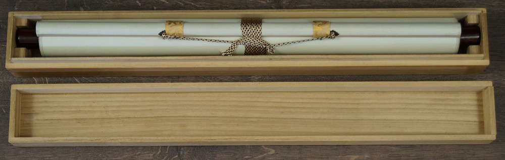 Rolled up hanging scroll in opened wooden box with cord hanging scroll in storage box