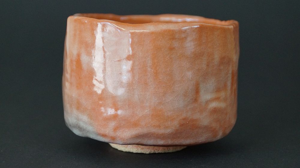Chawan tea bowl made of Raku ware by Ichiraku Nishimura in full view with flowing glaze structure