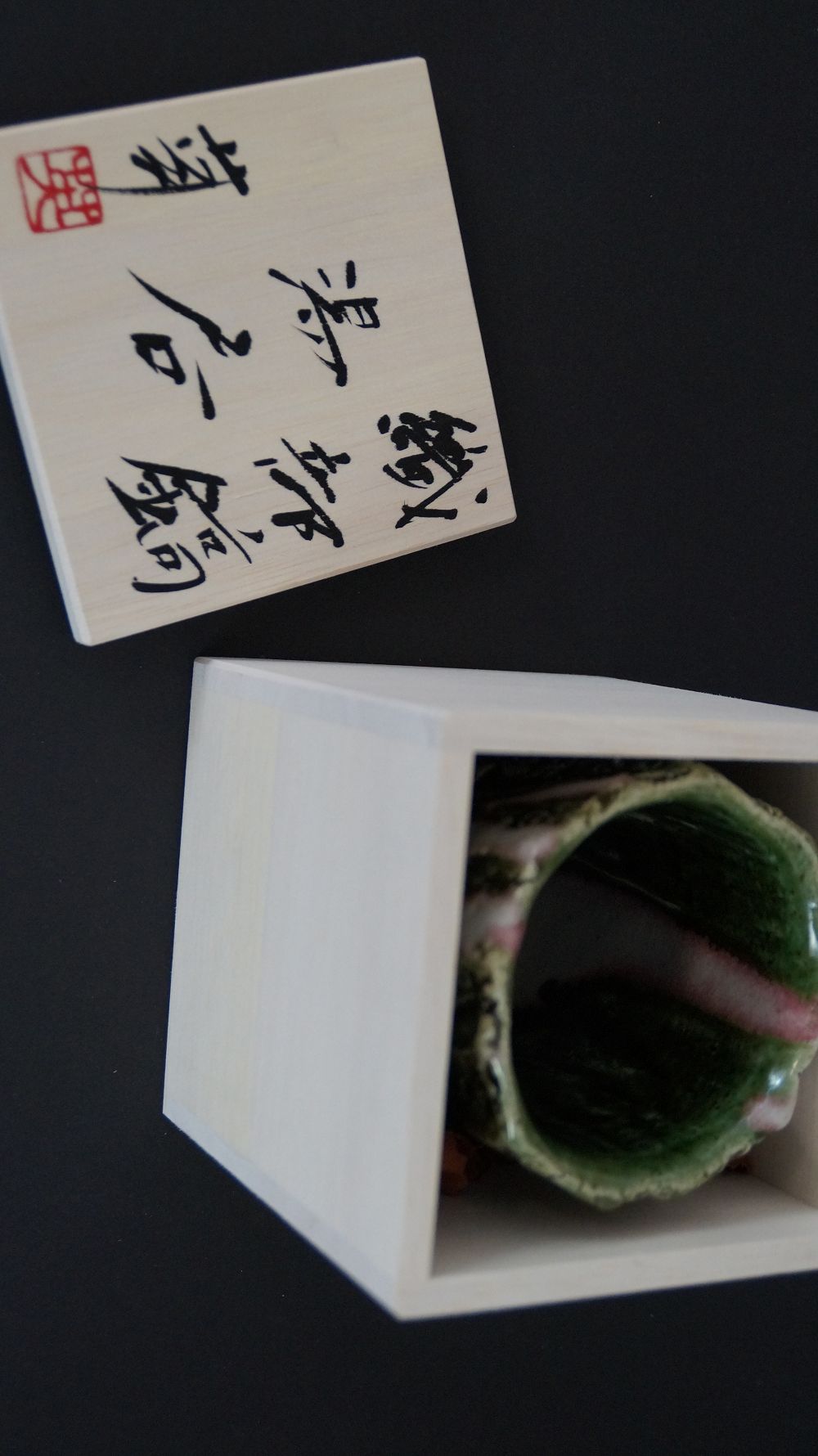 Yunomi tea bowl in the opened storage box next to the inscribed box lid