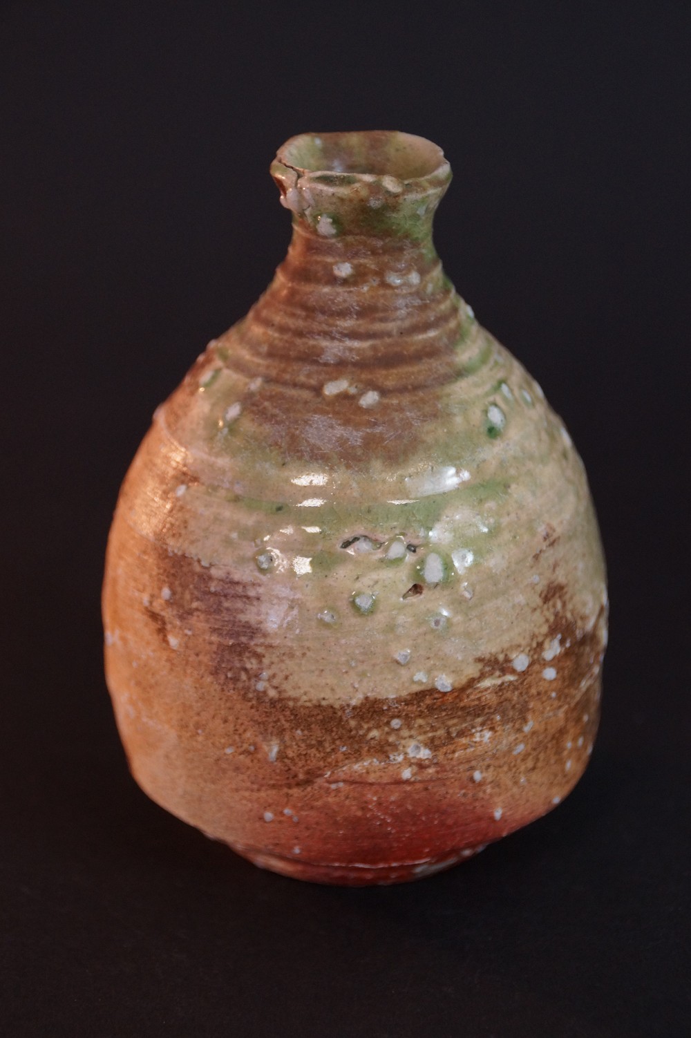 Another side view of the bulbous tokkuri with green neck and rust-red ash-glaze shading