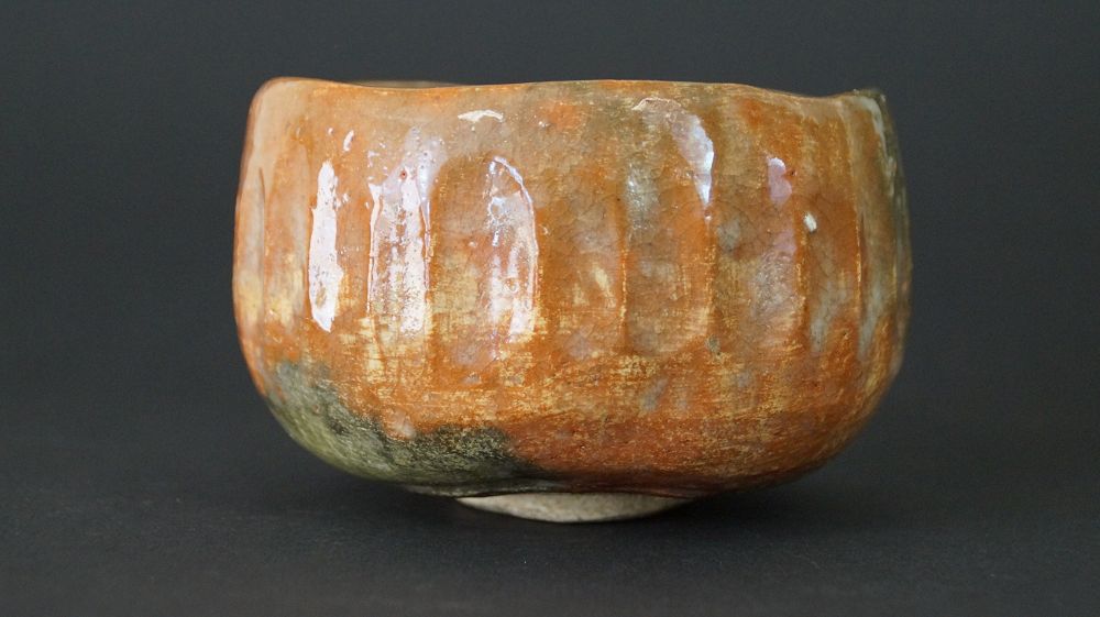 Further view of the chawan tea bowl made of Raku ware with flowing orange-green glaze