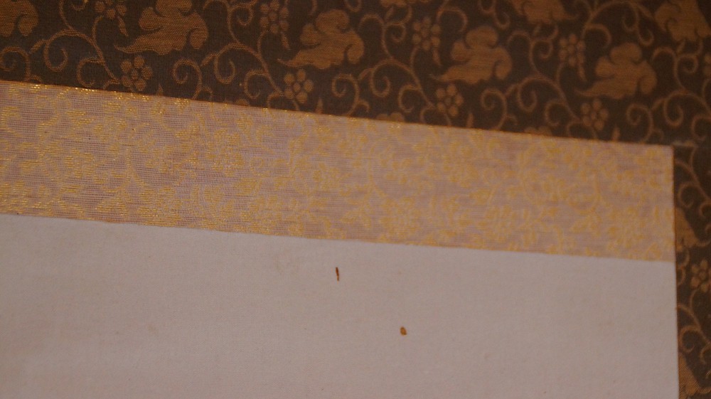 Detail of the golden-brown brocade mounting of the hanging scroll