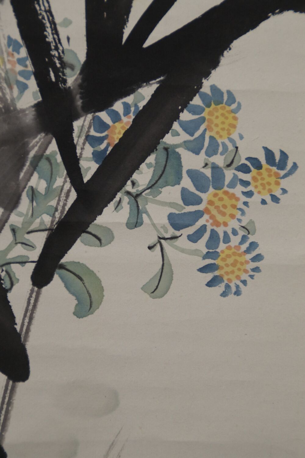 Macro shot of the blue-yellow asters between the bamboo leaves in the kakemono