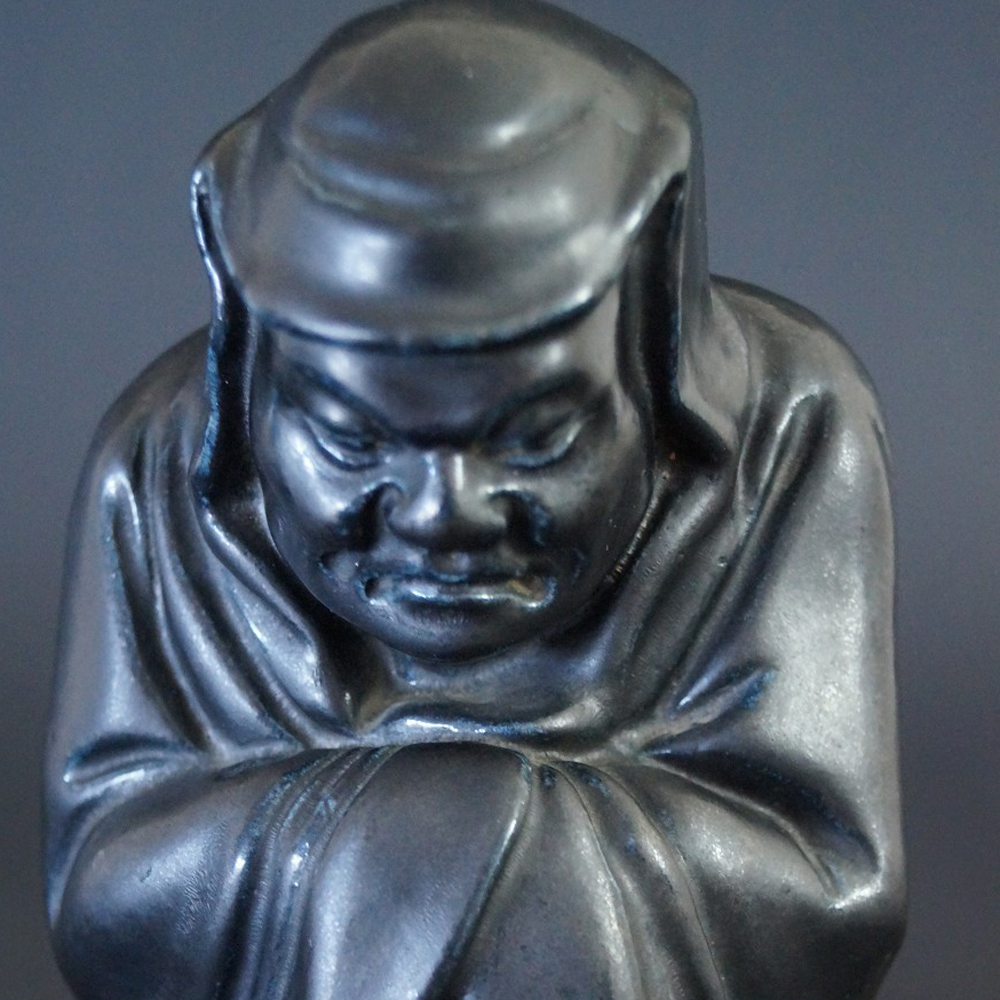 Bodhidharma Daruma Figur aus schwarzem Porzellan Motiv Nahaufnahme Vorschau