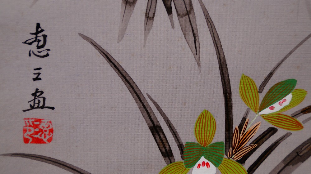 Extreme close-up of the artist signature Keizo and the red seal next to the painted orchid in the kakemono The Four Noble Plants