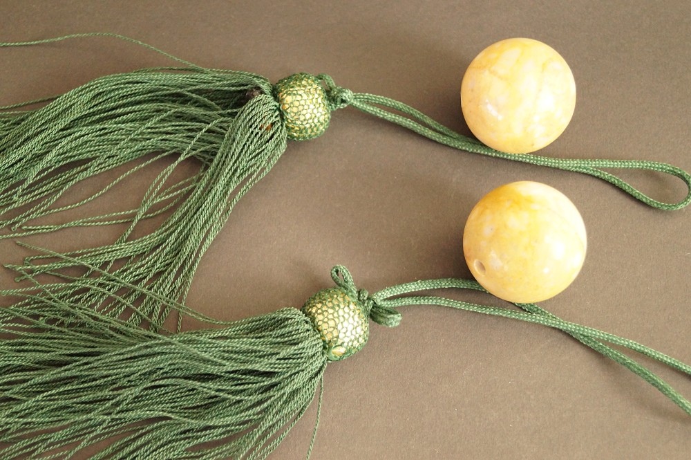 Two fuchin ornament weights with green cords and tassels set front view 1