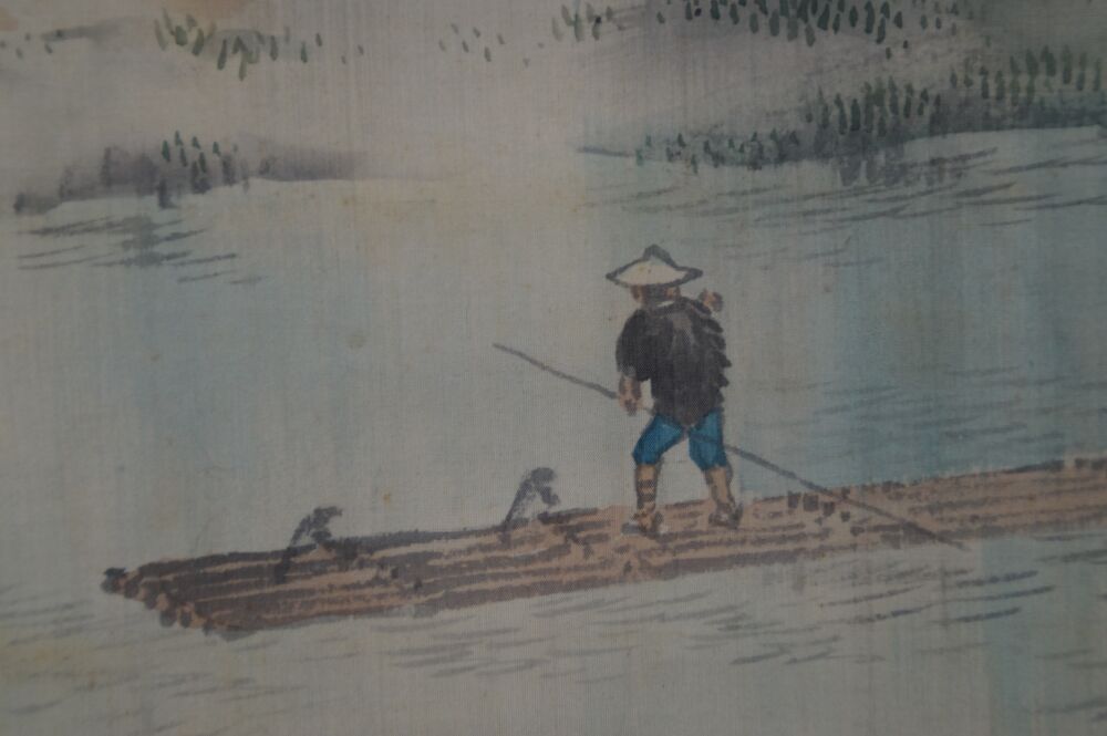 Nahaufnahme des Floessers mit Bambushut und Stange auf dem Floss im Kakemono Fluss im bluehenden Tal