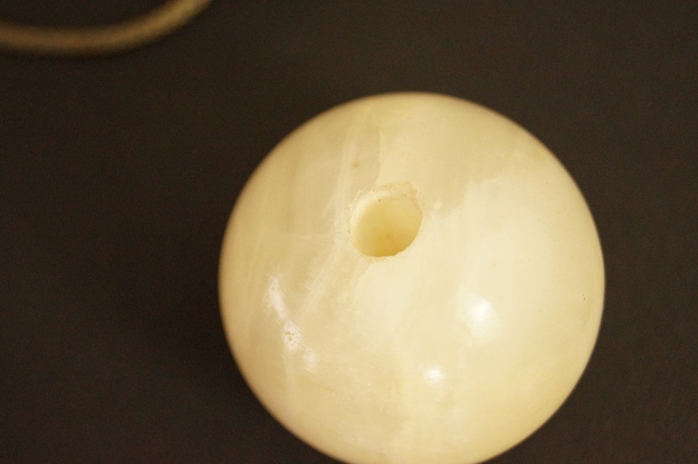 Light-colored stone sphere with drill hole in close-up stone close-up 2