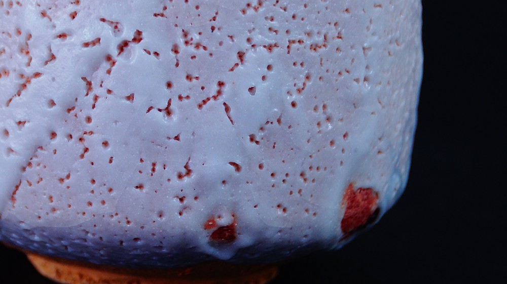 Close-up of the crackled Shino glaze with red fire marks of the chawan by Jyuzo Sato