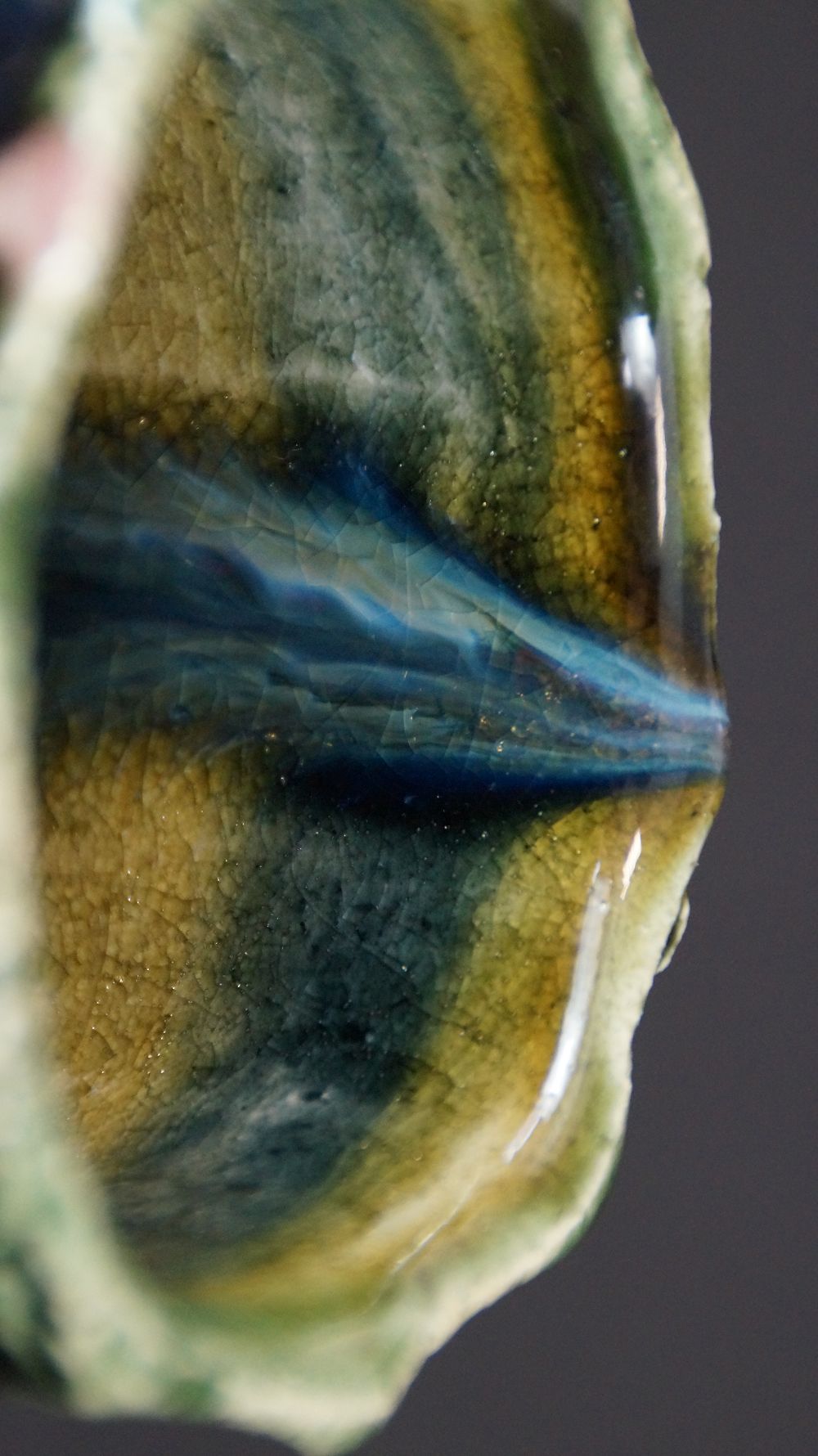 Close-up of the striped yellow-green-blue interior glaze of the Yunomi tea bowl made of Oribe ware